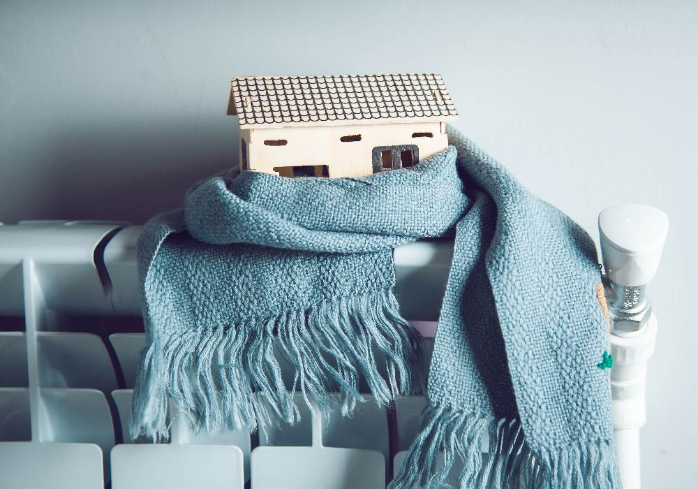 Picture of a miniature house with scarf on a radiator