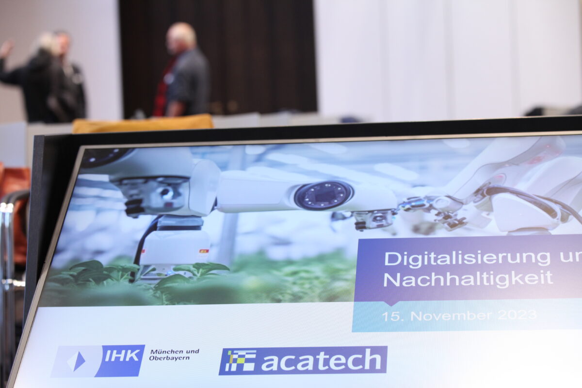 Screen shows the title of the event "Digitalisierung und Nachhaltigkeit" (“Digitalisation and Sustainability”) People in the background talking about the topic