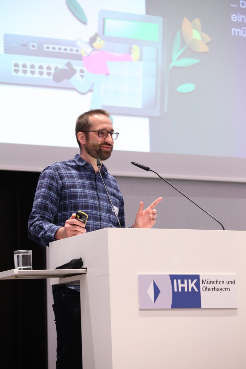 Yannick Möhring standing at the lectern in front of a screen on which his presentation can be seen